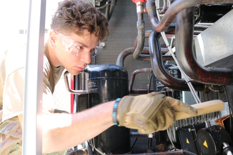 Technician servicing the compressor and coil of an HVAC system