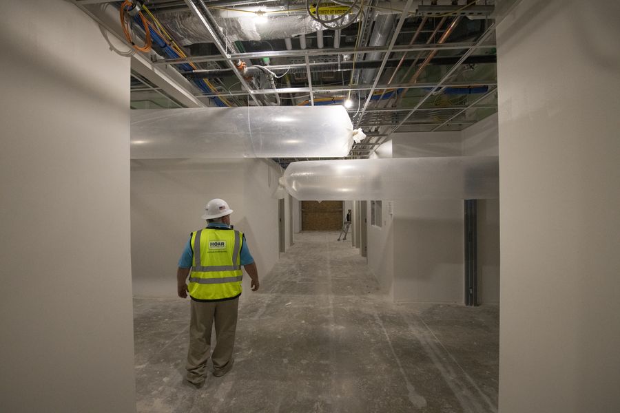 Maintenance technician in a high-visibility vest inspecting building HVAC services